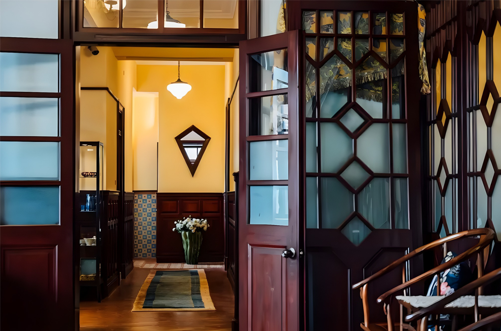 Interior of Chiang A-Hsin Mansion &mdash; European arched windows reflecting intricate cypress wood carvings, a century-old space where Eastern and Western aesthetics converge